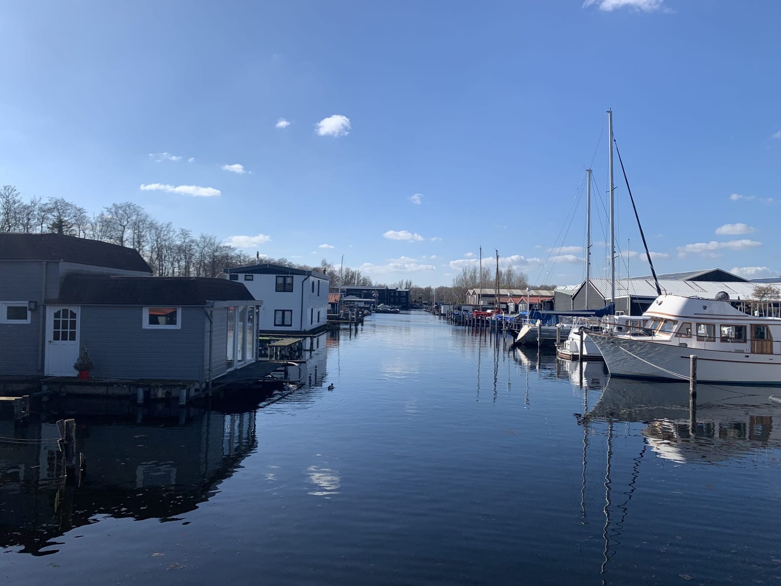 Boats and houseboats in the harbour under a blue sky